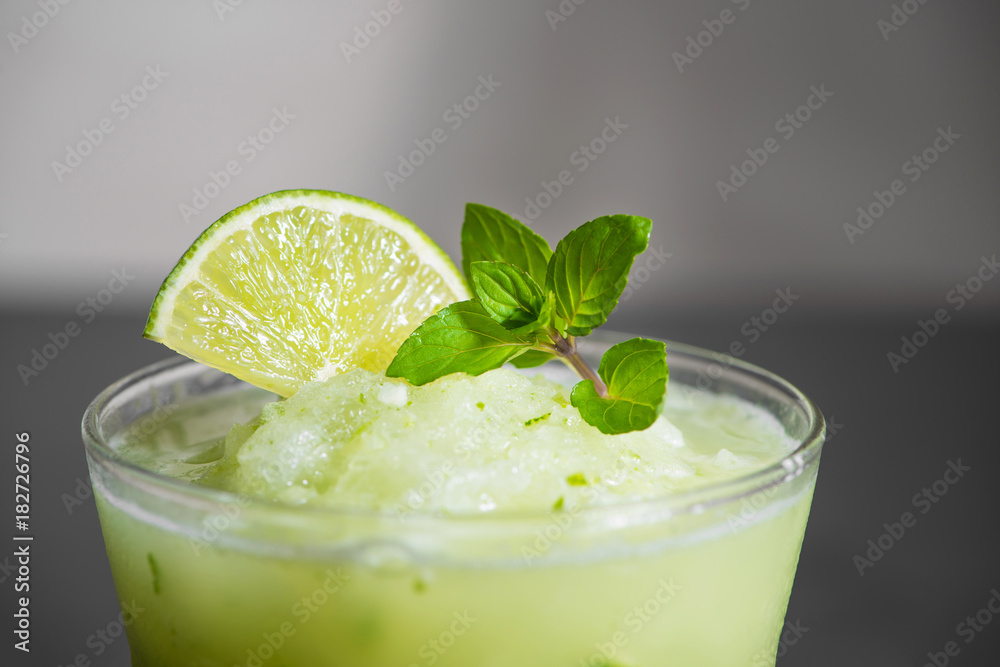 Cocktail juice with lime, mint and ice. Bar drink accessories on black table background.