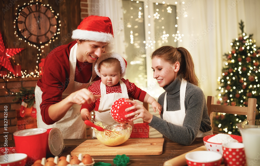 family mother father and baby bake christmas cookies