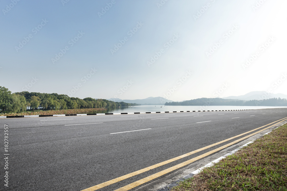 empty asphalt road with beautiful lake