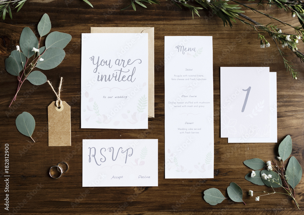 Wedding Invitation Cards Papers Laying on Table Decorate With Leaves