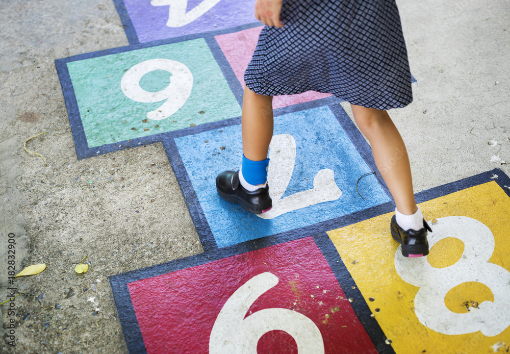 Kid playing hopscotch at school