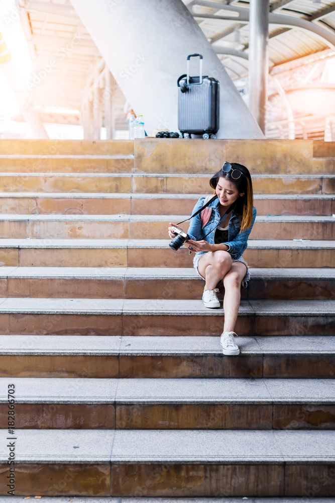 亚洲美女背着背包和行李箱旅行，城市背景旅行旅游创意c