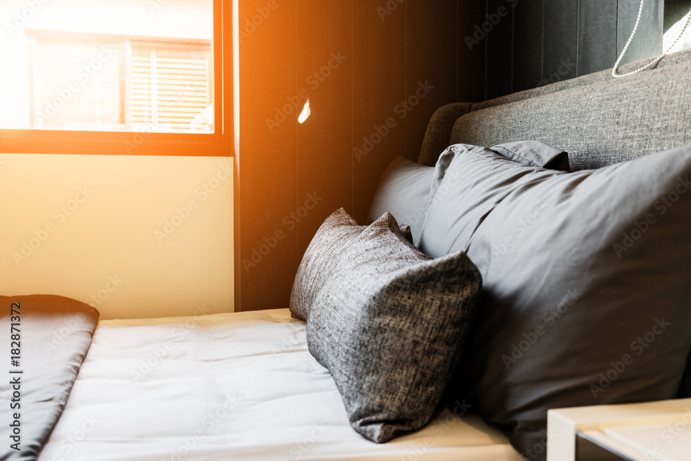 Bed maid-up with clean white pillows and bed sheets in beauty room. Close-up. Lens flair in sunlight