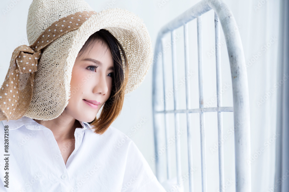 beautiful asian girl white white shirt ralax on white bed next to window curtian with sunlight beaut