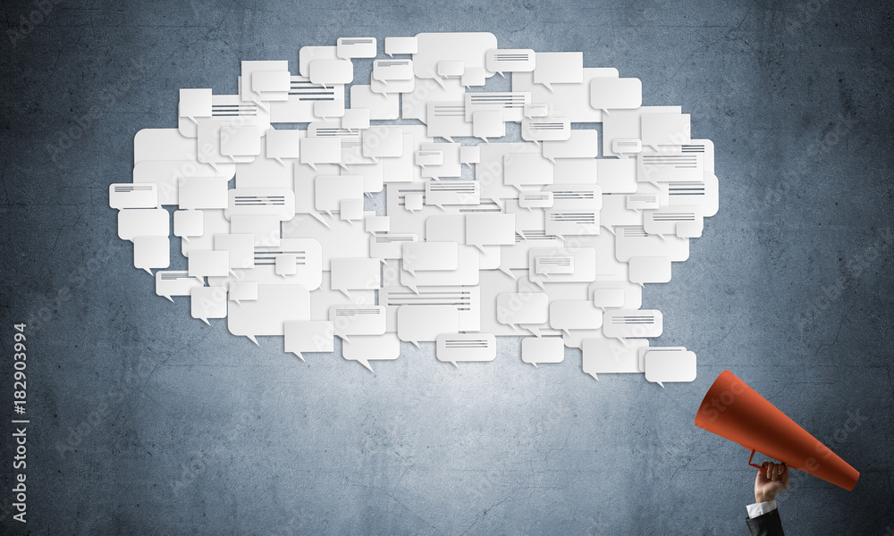 Hand of businesswoman holding red paper trumpet and speech cloud coming out