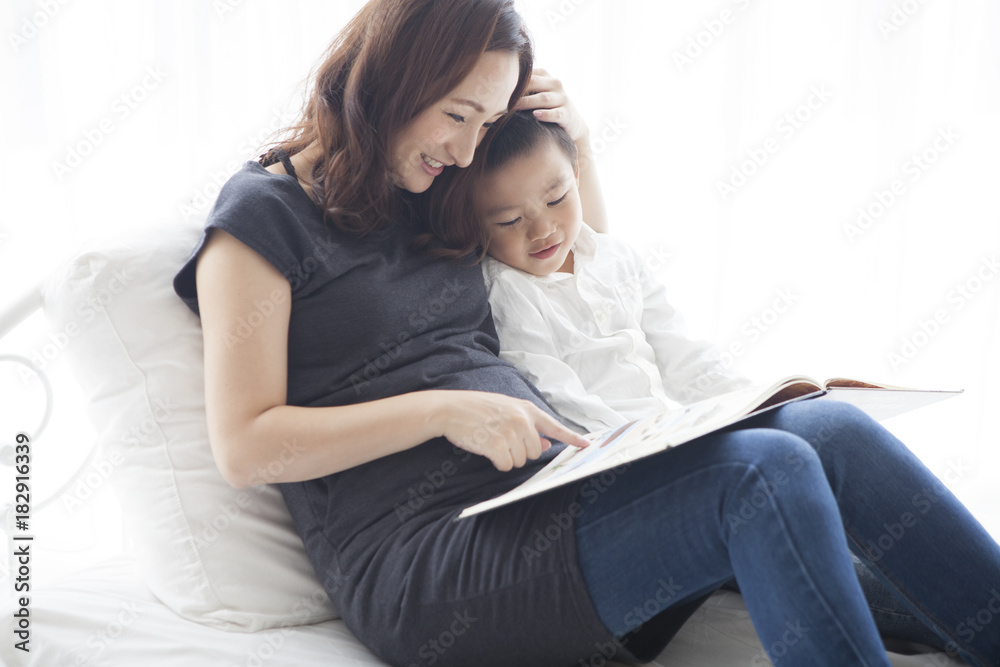 A boy who reads a book with his mother