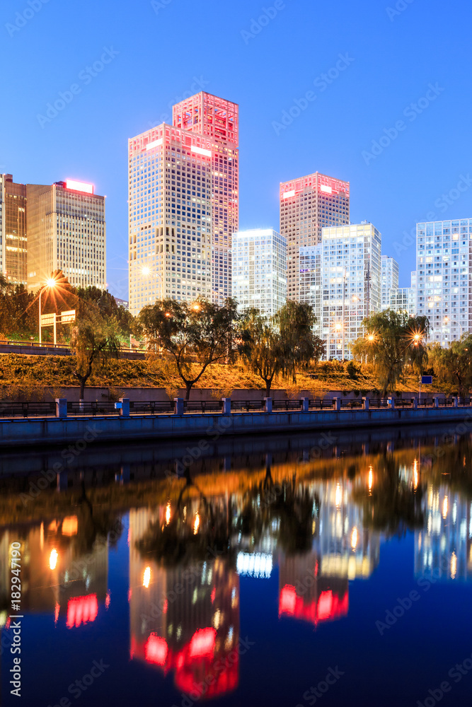 Business district office buildings and water reflection in Beijing at night