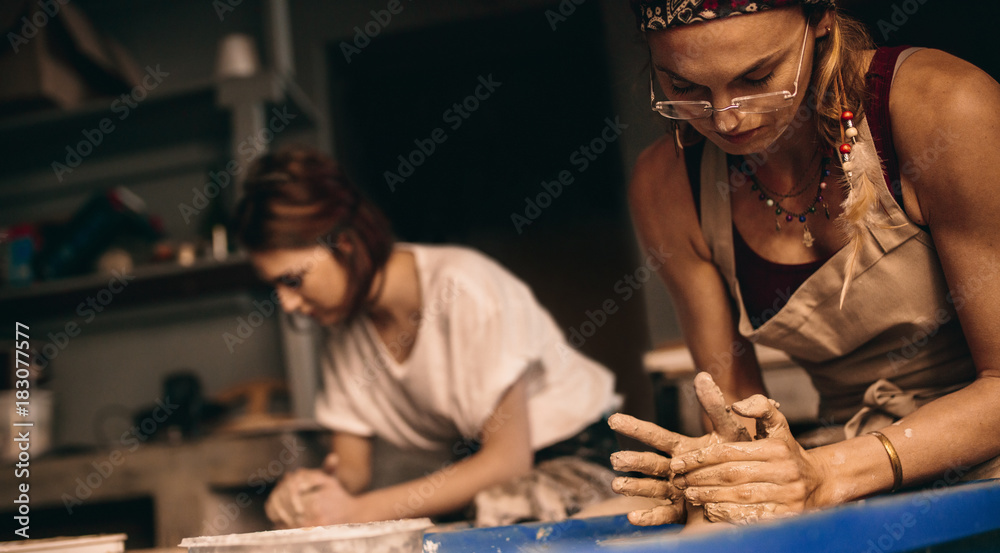 两名妇女在陶器作坊制作粘土壶