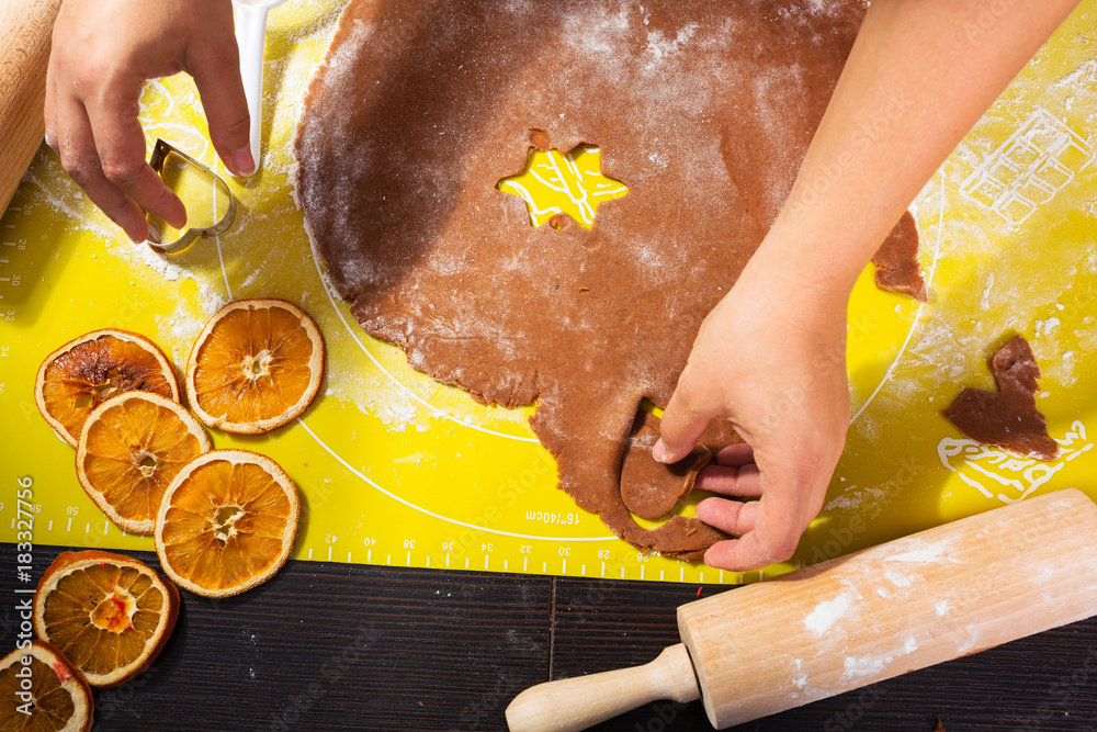 Top view of hands making gingerbread cookies for Christmas.