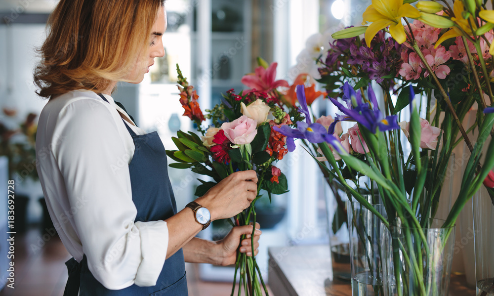 Florist preparing a bouquet with fresh flowers