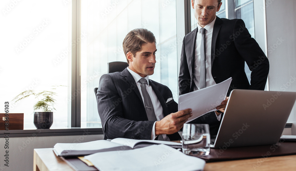 Corporate business people reading papers in office