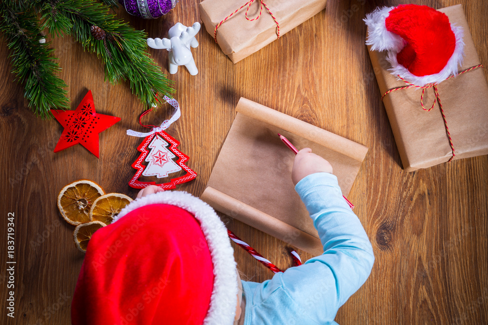 Top view of child writing letter to Santa Claus for Christmas