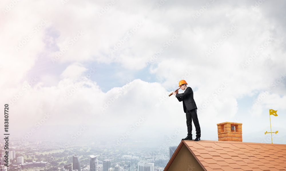 Engineer man standing on roof and looking in spyglass. Mixed media