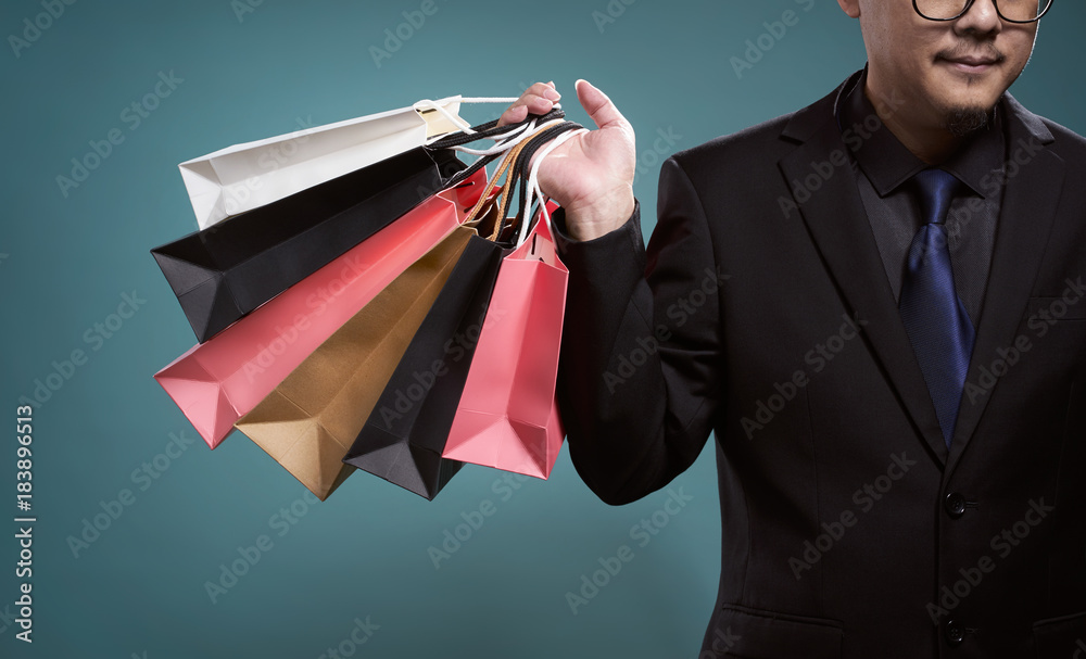 Close up of man with shopping bags , isolated on light blue background .