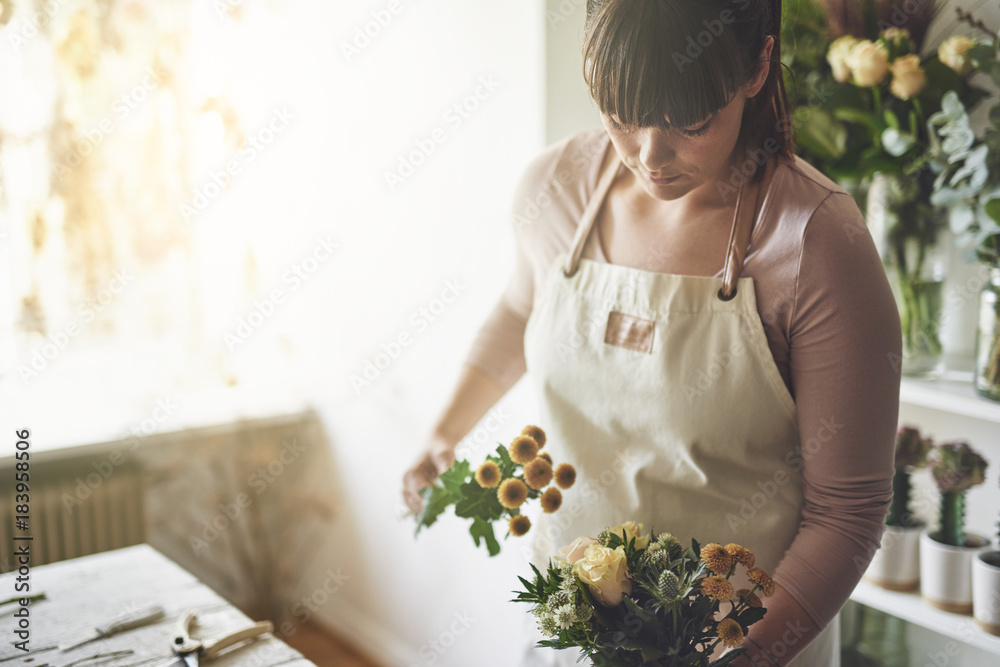 年轻的花商在她的花店里制作花束