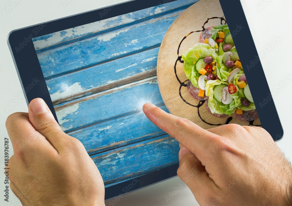 Hand touching tablet with food