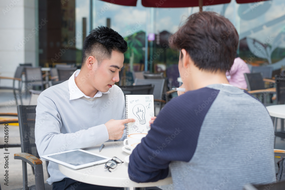 Handsome Asian business colleagues or college students work together using laptop, startup project m