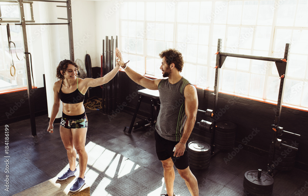 Athletes doing high five at gym