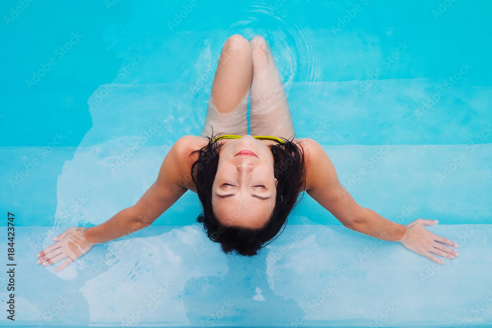  young girl is sunbathing in blue water