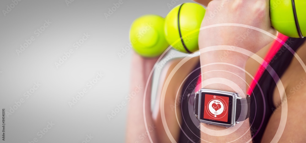 Composite image of happy woman lifting green dumbbells