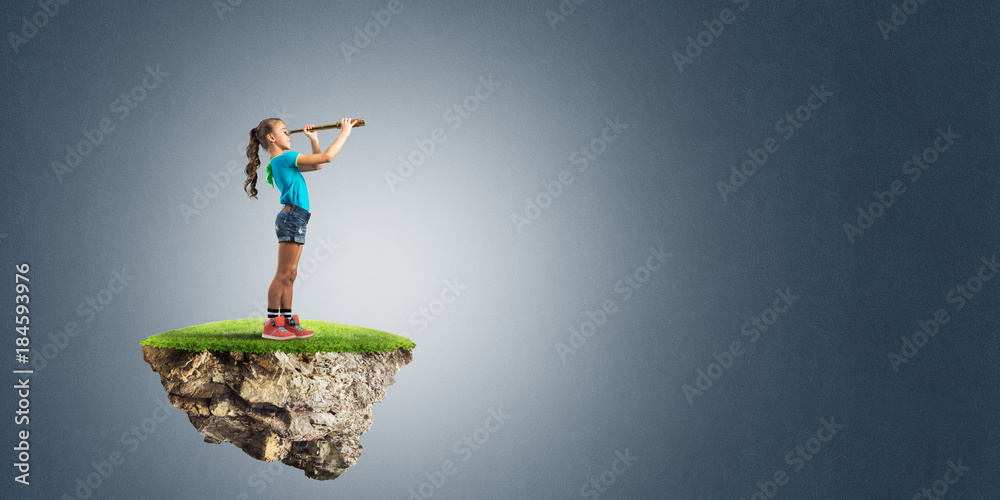 Concept of careless happy childhood with girl looking in spyglass