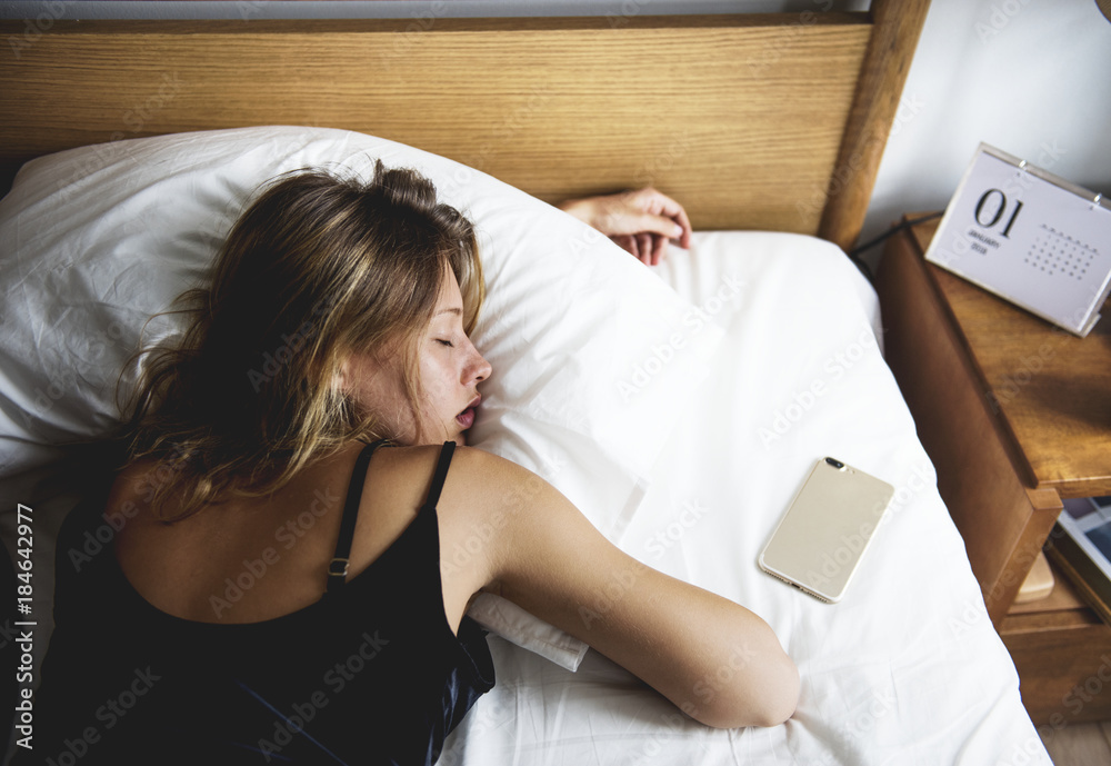 A Caucasian woman sleeping on her bed