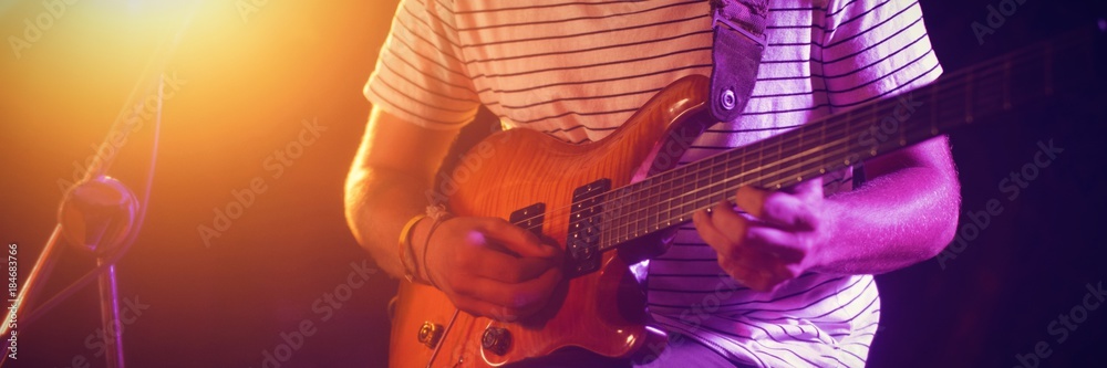 Mid section of male guitarist performing