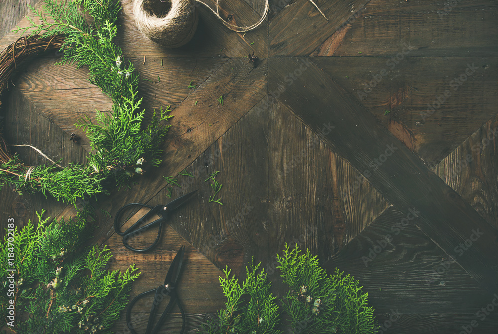 Preparing for Christmas or New Year holiday. Flat-lay of fur tree branches, wreaths, rope, scissors 