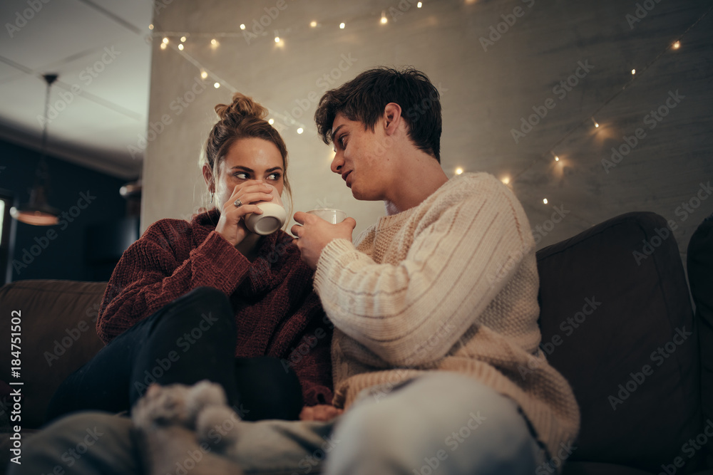 Couple relaxing on sofa having coffee