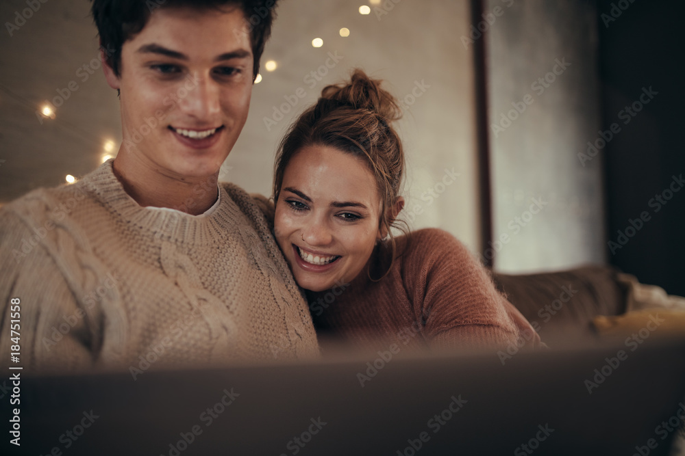 Hygge couple sitting on sofa with a laptop