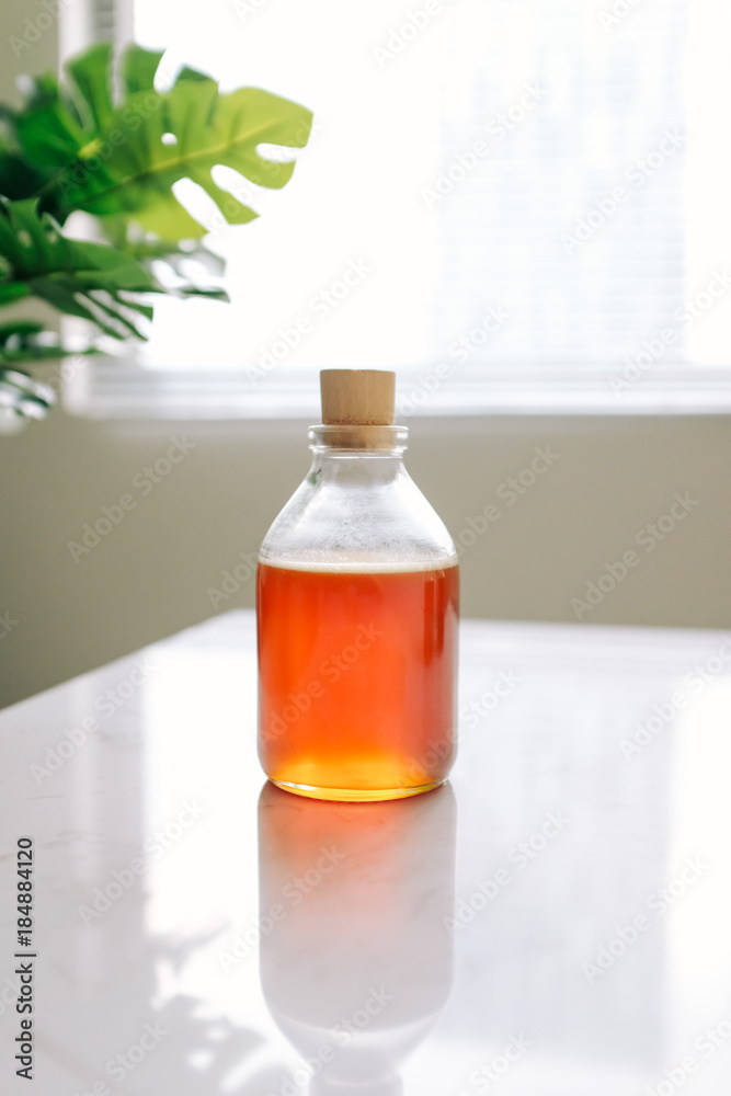 Glass can full of honey on table.