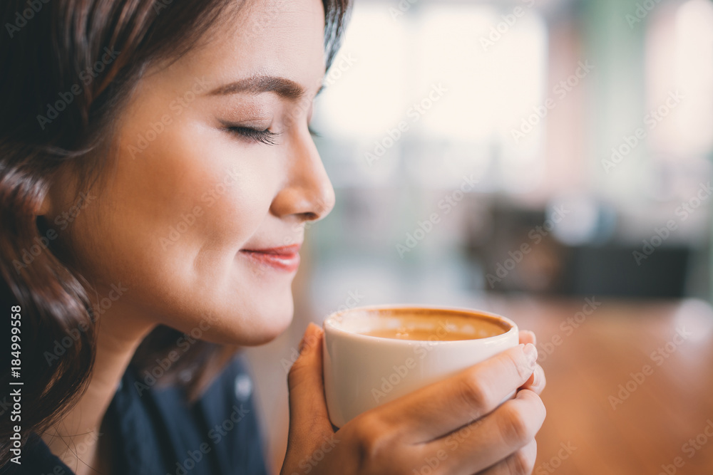 Portrait of attractive young asian woman drinking coffee