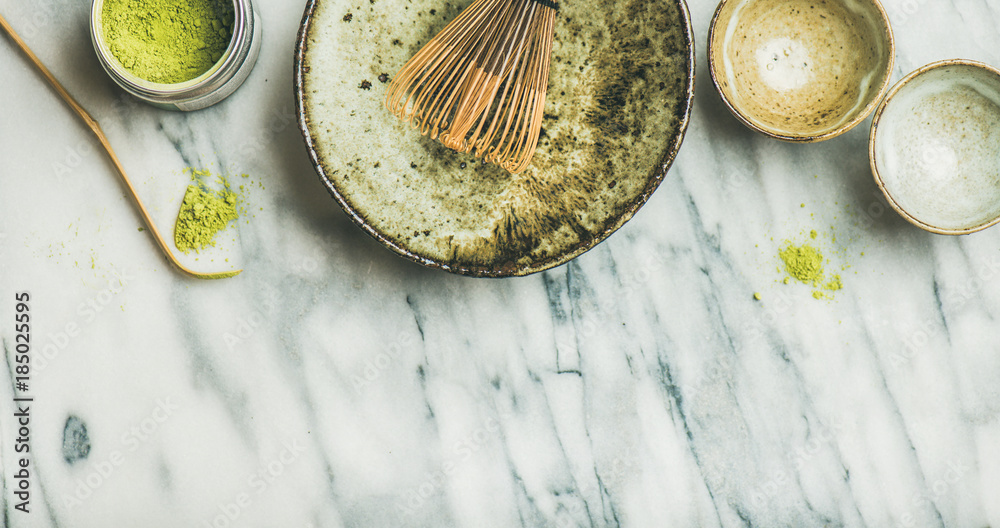 Flat-lay of Japanese tools and bowls for brewing matcha tea. Matcha powder in tin can, Chashaku spoo