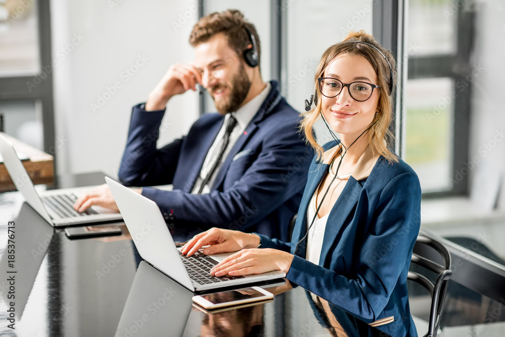 Business coworkers dressed in suits having oline conference with headset and laptop sitting at the o