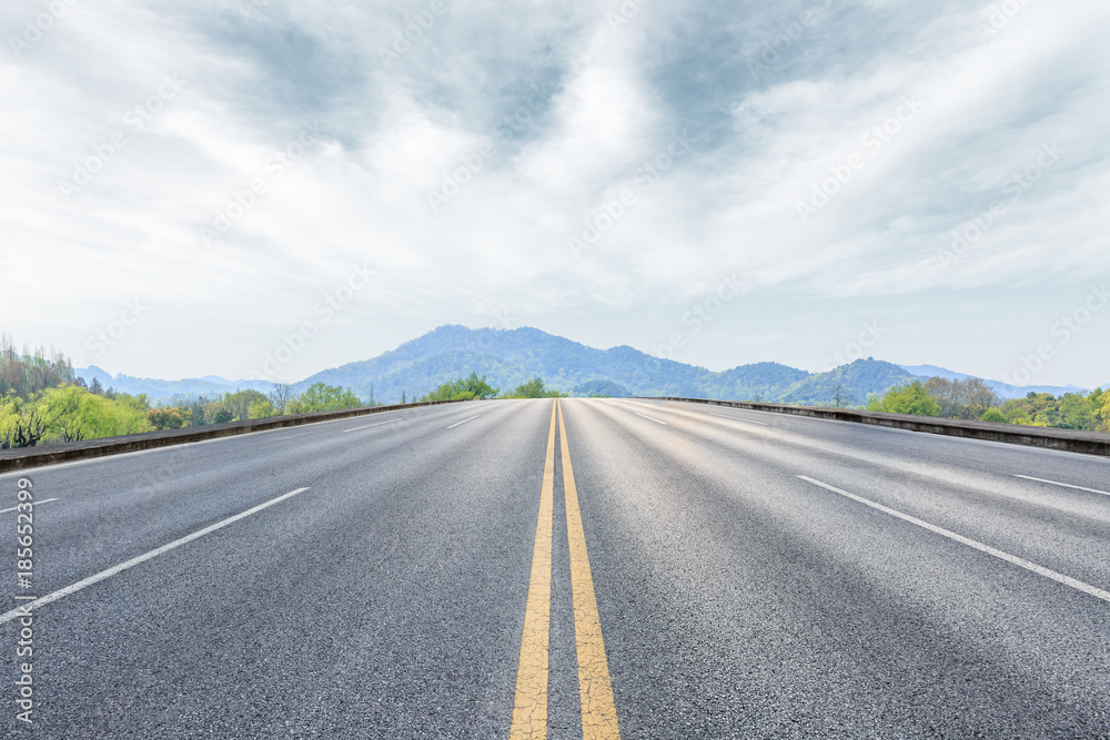 empty asphalt highway and mountain natural scenery under the blue sky