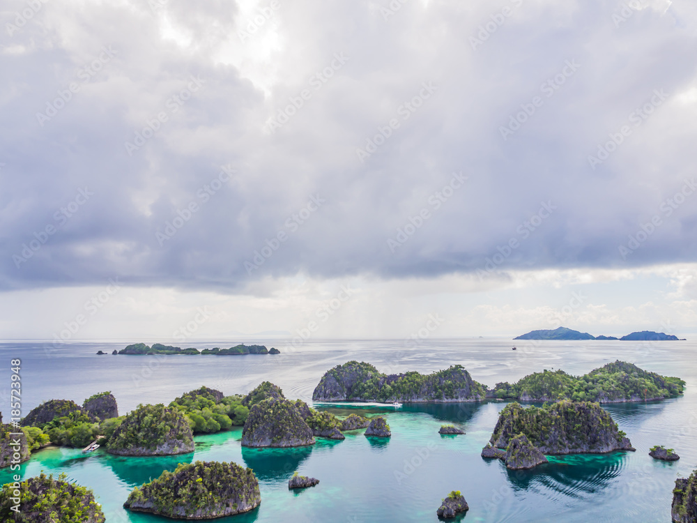 Wonderful island shape with forest, clear turquoise sea and cloudy day.