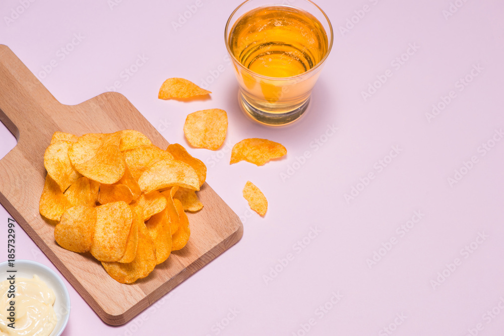 Cheese and onion potato chips with soft drink on pink background.