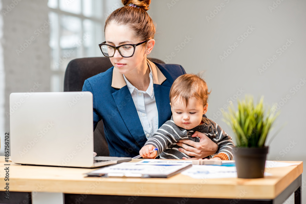 Young multitasking businessmam dressed in the suit working with laptop and documents sitting with he