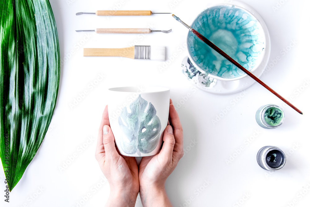 painted ceramic cup on white background top view