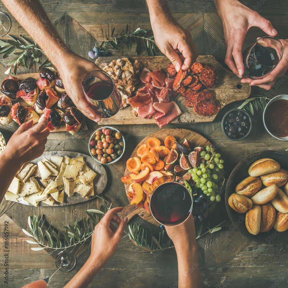 Flat-lay of friends hands eating and drinking together. Top view of people having party, celebrating