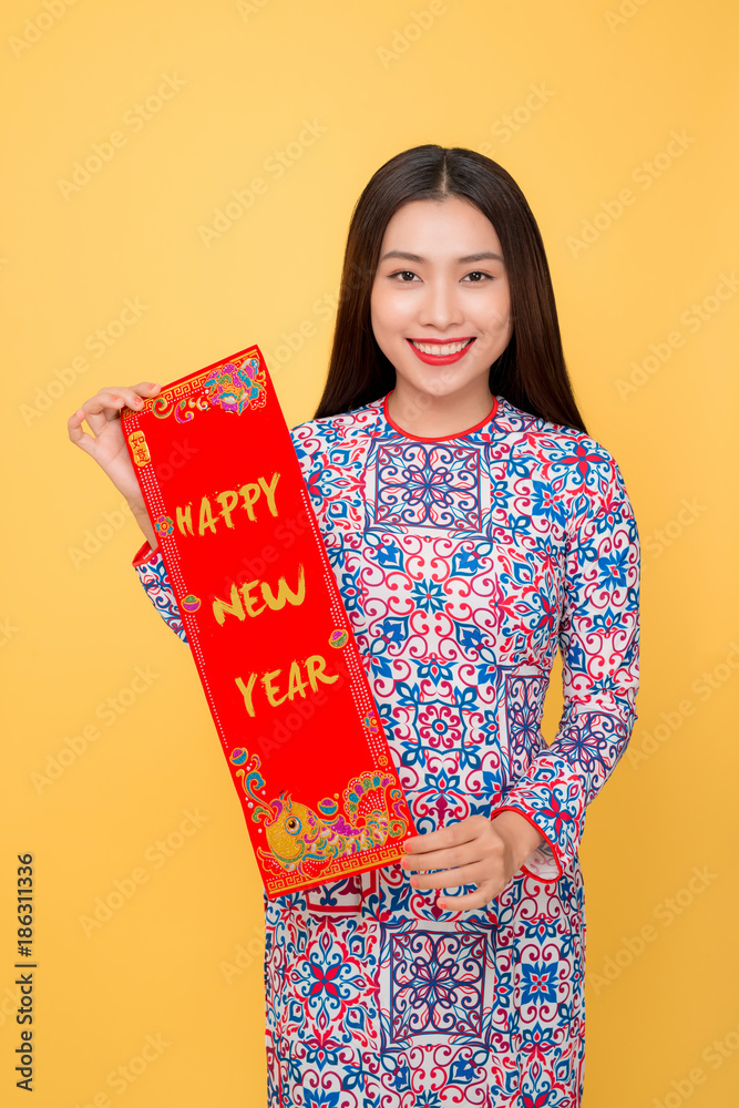 Vietnamese woman traditional festival costume Ao Dai showing New Year scrolls.