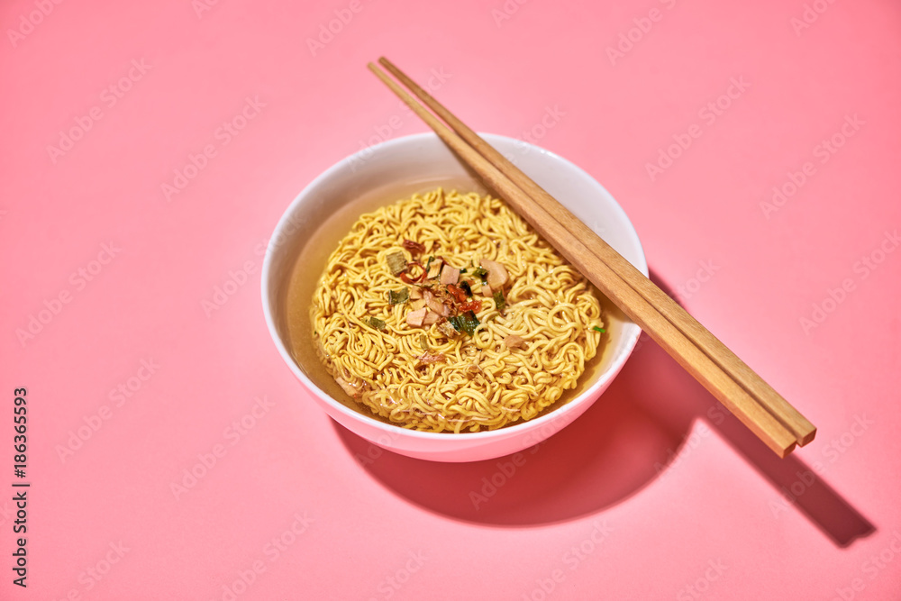 A Bowl of instant noodles on pink background