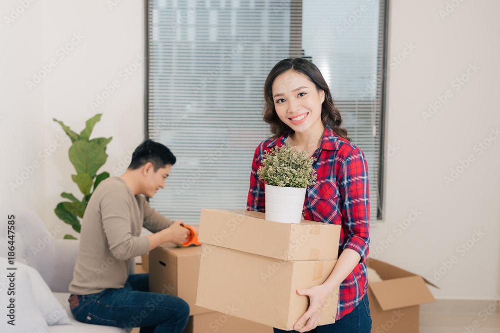 Happy young couple moving into new apartment with packaging boxes