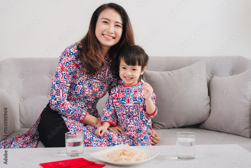 越南母亲和女儿在家庆祝新年。春节。