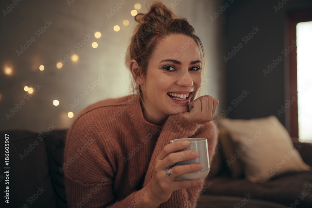 微笑的女人坐在家里喝咖啡