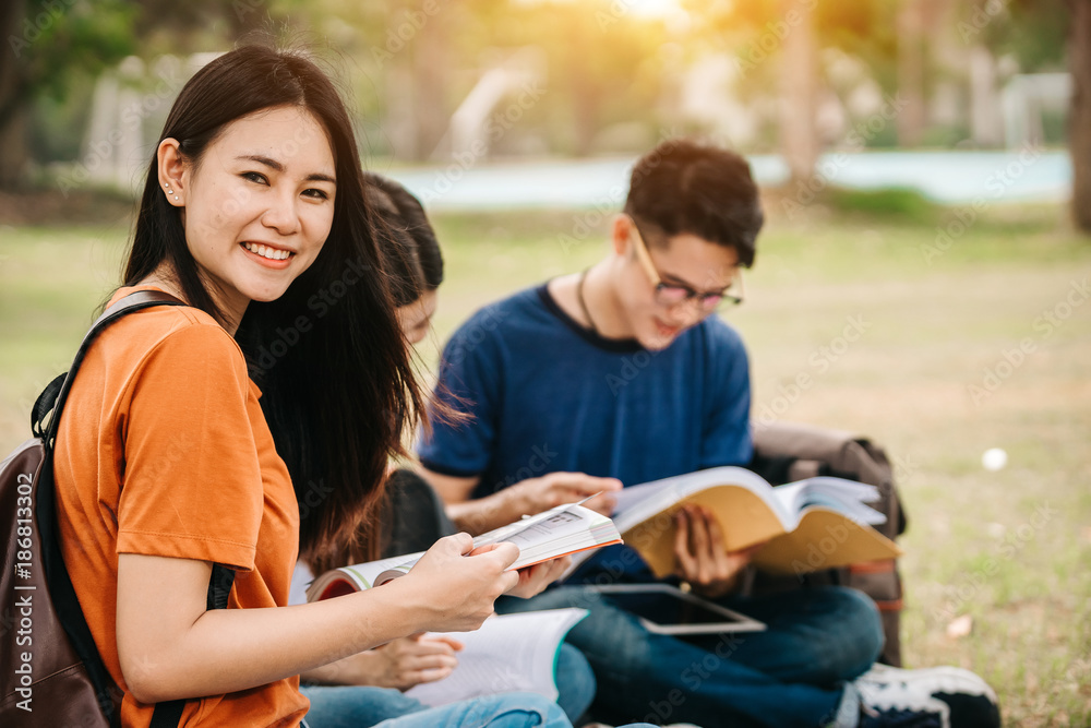 A group of young or teen Asian student in university smiling and reading the book and look at the ta