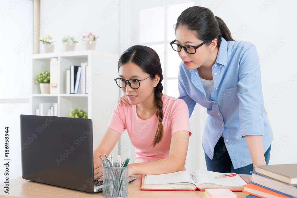 微笑的漂亮女学生使用手机电脑