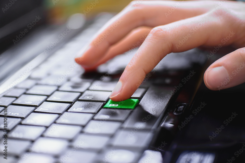 Girls finger presses thegreen key letter B on the keyboard of the computer. Concept – BE GREEN