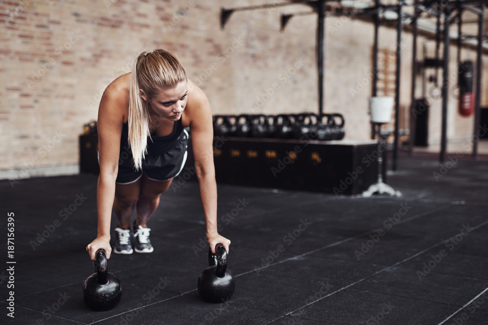 Fit young woman working out with weights in a gym