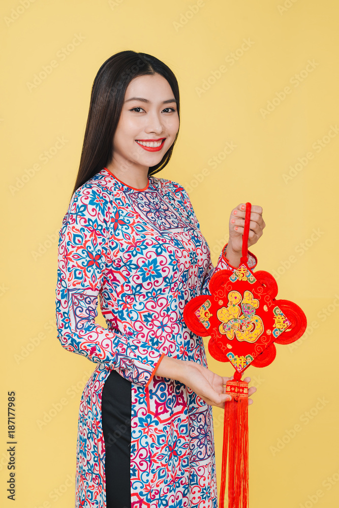 Attractive asian woman wearing traditional costume, isolated on yellow background. Text mean Happine